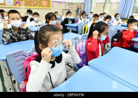 200525 -- GUIYANG, le 25 mai 2020 -- des élèves apprennent à porter des masques faciaux dans une école primaire de Guiyang, dans la province du Guizhou, au sud-ouest de la Chine, le 25 mai 2020. Les écoles primaires de Guiyang reprennent progressivement les cours. CHINE-GUIYANG-L'ÉCOLE PRIMAIRE-RÉOUVERTURE CN YANGXWENBIN PUBLICATIONXNOTXINXCHN Banque D'Images