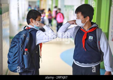 200526 -- PÉKIN, le 26 mai 2020 -- deux élèves se saluent en se touchant les coudes dans une école primaire de Guiyang, dans la province du Guizhou, au sud-ouest de la Chine, le 25 mai 2020. Les écoles primaires de Guiyang reprennent progressivement les cours. PHOTOS XINHUA DU JOUR LiuxXu PUBLICATIONxNOTxINxCHN Banque D'Images