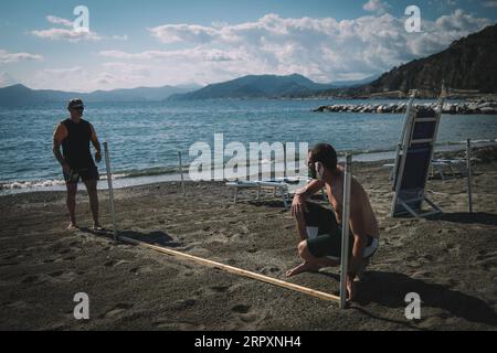 200530 -- GÊNES, le 30 mai 2020 Xinhua -- des travailleurs mesurent la distance sur la plage pour placer des parasols à Gênes, Italie, le 29 mai 2020. Après que certaines restrictions sur la circulation des personnes imposées depuis mars 10 avec le confinement ont été progressivement levées ces dernières semaines, voyager dans la même région de résidence n'a été autorisé qu'à partir de mai 18. La prochaine étape dans le calendrier officiel du gouvernement serait, en fait, de rouvrir le déménagement entre les régions italiennes d'ici juin 3. Photo de Federico Tardito/Xinhua ITALIE-GÊNES-PLAGE-RÉOUVERTURE-PRÉPARATION PUBLICATIONxNOTxINxCHN Banque D'Images