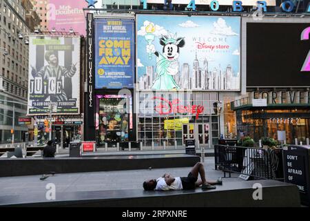 200530 -- NEW YORK, le 30 mai 2020 -- Un homme dort sur un banc de pierre à Times Sqaure à New York, aux États-Unis, le 29 mai 2020. New York City, épicentre de la pandémie de COVID-19 aux États-Unis, devrait entrer dans la première phase du processus de réouverture le 8 juin, a déclaré vendredi le gouverneur de l’État de New York Andrew Cuomo. PROCESSUS DE RÉOUVERTURE DE LA VILLE DE NEW YORK WANGXYING PUBLICATIONXNOTXINXCHN Banque D'Images