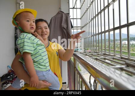 200604 -- XIUSHUI, le 4 juin 2020 -- l'épouse du villageois réinstallé Hu Shanghai passe du temps avec l'un de ses enfants dans sa nouvelle maison dans une communauté de réinstallation de lutte contre la pauvreté dans le canton de Shangfeng, dans le comté de Xiushui, dans l'est de la Chine, dans la province de Jiangxi, le 21 mai 2020. La famille a déménagé ici en 2017. Au cours de la période du 13e Plan quinquennal 2016-2020 de la Chine, le gouvernement local de Xiushui a construit 141 communautés de réinstallation pour plus de 10 000 habitants ruraux pauvres, qui avaient l'habitude de lutter contre la vie dans les zones montagneuses du comté. Les résidents ruraux réinstallés ont désormais accès à un meilleur hospita Banque D'Images