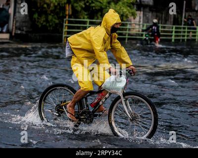 200612 -- PÉKIN, le 12 juin 2020 -- Un homme conduit à vélo dans une zone inondée causée par les fortes pluies de la dépression tropicale nommée localement Butchoy à Manille, aux Philippines, le 11 juin 2020. PHOTOS XINHUA DU JOUR ROUELLExUMALI PUBLICATIONxNOTxINxCHN Banque D'Images