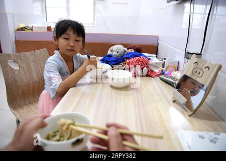 200612 -- HEFEI, le 12 juin 2020 -- Chu Siyang dîne avec son père dans le village de Wangli, dans le comté de Yingshang, province de l'Anhui, dans l'est de la Chine, le 9 juin 2020. CHU Siyang est une jeune fille de 9 ans dont les parents sont tous deux des travailleurs de la base engagés dans la lutte pour l'éradication de la pauvreté dans le pays. En 2017, Zheng Jiawei, père de Siyang, s'est porté volontaire pour travailler comme travailleur de base dans le village de Wangli, dans le comté de Yingshang, aidant les villageois locaux à se débarrasser de la pauvreté et à développer les infrastructures. Sa mère, déjà occupée à travailler sur la ligne de front des villages frappés par la pauvreté, ne pouvait pas perdre de temps pour s’occuper de Siyang. Banque D'Images