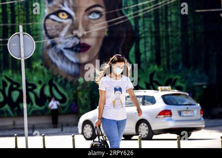 200616 -- BITOLA, 16 juin 2020 Xinhua -- Une femme portant un masque facial passe devant une fresque dans la rue de la ville de Bitola, à 180 km au sud de la capitale Skopje, Macédoine du Nord, le 15 juin 2020. Lundi, le ministère de la Santé a signalé 103 nouveaux cas de coronavirus, portant le total à 4 157, avec 1 723 reprises et 193 décès. Photo Tomislav Georgiev/Xinhua MACÉDOINE DU NORD-BITOLA-COVID-19-CAS PUBLICATIONxNOTxINxCHN Banque D'Images