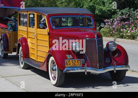 Ford V8 Woody Station Wagon 1936 montré conduisant dans un quartier résidentiel. Banque D'Images