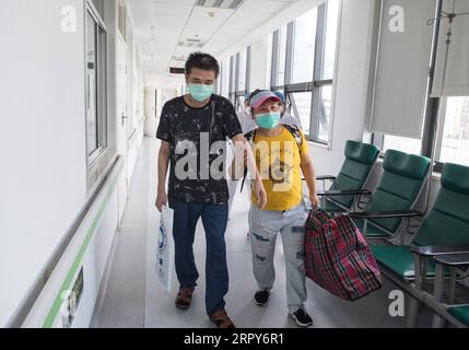 200617 -- WUHAN, le 17 juin 2020 -- Hu Dingjiang et sa femme sortent d'un service de l'hôpital pulmonaire de Wuhan à Wuhan, dans la province du Hubei au centre de la Chine, le 17 juin 2020. Hu Dingjiang, 40 ans, un patient guéri du COVID-19, a quitté l’hôpital pulmonaire de Wuhan mercredi après avoir reçu un traitement médical et une formation de réadaptation pendant plus de 100 jours. Il a été diagnostiqué avec la maladie au début de février et a été hospitalisé dans le service de soins intensifs comme l’un des 81 cas graves de COVID-19 à l’hôpital. Les fonctions de ses poumons ont récupéré le 5 avril avec 40 jours d'oxygénatio membranaire extracorporelle Banque D'Images