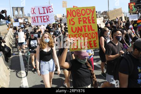 200620 -- NEW YORK, le 20 juin 2020 -- des manifestants défilent à travers le pont de Brooklyn à New York, aux États-Unis, le 19 juin 2020. Vendredi, les New-Yorkais ont marqué le dix-septième juin, le jour commémorant l'émancipation des Afro-Américains asservis, avec des marches et des protestations alors que le pays connaît un nouveau moment de prise en compte de l'injustice raciale. US-NEW YORK-JUNETEENTH-DÉMONSTRATION WangxYing PUBLICATIONxNOTxINxCHN Banque D'Images