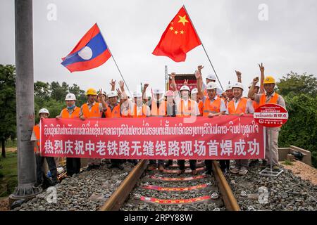 200620 -- VIENTIANE, 20 juin 2020 Xinhua -- des travailleurs du China Railway No.2 Engineering Group CREC-2 posent pour une photo de groupe après avoir soudé les premiers rails sans soudure pour le chemin de fer Chine-Laos dans la banlieue nord de Vientiane, Laos, le 18 juin 2020. Le CREC-2 a soudé jeudi matin les premiers rails sans soudure pour le chemin de fer Chine-Laos dans la banlieue nord de Vientiane, la capitale laotienne. Le rail sans soudure, également connu sous le nom de rail soudé continu CWR qui élimine les joints de rail, peut améliorer la durée des rails en acier, réduire les coûts de maintenance des locomotives et des voies, améliorer le stabil Banque D'Images