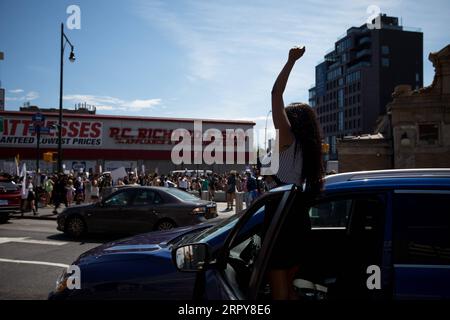 200620 -- NEW YORK, le 20 juin 2020 -- Une femme lève le poing en l'air lors d'une manifestation de Black Lives Matter commémorant le dix-septième juin dans le quartier de Brooklyn à New York, aux États-Unis, le 19 juin 2020. Vendredi, les New-Yorkais ont marqué le dix-septième juin, le jour commémorant l'émancipation des Afro-Américains asservis, avec des marches et des protestations alors que le pays connaît un nouveau moment de prise en compte de l'injustice raciale. Photo de /Xinhua U.S.-NEW YORK-JUNETEENTH-DÉMONSTRATION MichaelxNagle/WANGxYing PUBLICATIONxNOTxINxCHN Banque D'Images