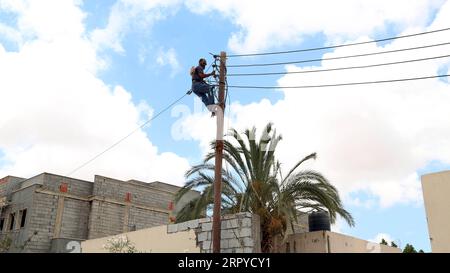 200625 -- TRIPOLI, le 25 juin 2020 Xinhua -- Un ouvrier de maintenance de la Libyan Electricity Company change de câbles dans la région de Salah al-DIN, au sud de Tripoli, en Libye, le 23 juin 2020. La plupart des villes libyennes, en particulier Tripoli, souffrent de coupures de courant quotidiennes qui durent jusqu'à 12 heures, surtout en hiver et en été. Le déficit électrique est de près de 2 500 mégawatts par jour, alors que la production actuelle ne dépasse pas 5 000 mégawatts par jour. Photo de Mohamed Arhoma/Xinhua TO GO WITH : les coupures de courant augmentent la souffrance du peuple libyen LIBYA-TRIPOLI-COUPURES DE COURANT PUBLICATIONxNOTxINxCHN Banque D'Images