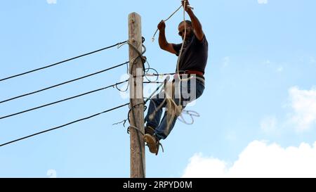 200625 -- TRIPOLI, le 25 juin 2020 Xinhua -- Un ouvrier de maintenance de la Libyan Electricity Company change de câbles dans la région de Salah al-DIN, au sud de Tripoli, en Libye, le 23 juin 2020. La plupart des villes libyennes, en particulier Tripoli, souffrent de coupures de courant quotidiennes qui durent jusqu'à 12 heures, surtout en hiver et en été. Le déficit électrique est de près de 2 500 mégawatts par jour, alors que la production actuelle ne dépasse pas 5 000 mégawatts par jour. Photo de Mohamed Arhoma/Xinhua TO GO WITH : les coupures de courant augmentent la souffrance du peuple libyen LIBYA-TRIPOLI-COUPURES DE COURANT PUBLICATIONxNOTxINxCHN Banque D'Images