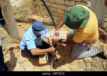 200625 -- TRIPOLI, le 25 juin 2020 Xinhua -- des ouvriers d'entretien de la compagnie libyenne d'électricité réparent une ligne dans la région de Salah al-DIN, au sud de Tripoli, en Libye, le 23 juin 2020. La plupart des villes libyennes, en particulier Tripoli, souffrent de coupures de courant quotidiennes qui durent jusqu'à 12 heures, surtout en hiver et en été. Le déficit électrique est de près de 2 500 mégawatts par jour, alors que la production actuelle ne dépasse pas 5 000 mégawatts par jour. Photo de Mohamed Arhoma/Xinhua TO GO WITH : les coupures de courant augmentent la souffrance du peuple libyen LIBYA-TRIPOLI-COUPURES DE COURANT PUBLICATIONxNOTxINxCHN Banque D'Images