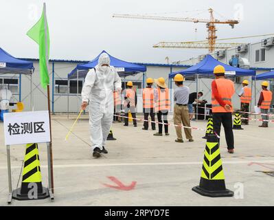 200626 -- PÉKIN, le 26 juin 2020 -- Un membre du personnel L, front désinfecte une installation de test d'acides nucléiques COVID-19 installée temporairement sur un chantier de construction dans le district de Haidian à Pékin, capitale de la Chine, le 26 juin 2020. Plus de 1 750 travailleurs de la construction à Pékin ont reçu vendredi des tests d’acide nucléique COVID-19. CHINE-PÉKIN-COVID-19-TEST D'ACIDE NUCLÉIQUE CN RENXCHAO PUBLICATIONXNOTXINXCHN Banque D'Images