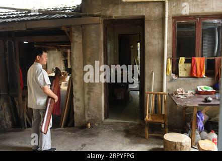 200630 -- HANGZHOU, le 30 juin 2020 -- Ma Yuesi transporte Guqin, un instrument de musique chinois traditionnel, dans son atelier à son domicile dans le village de Yalan, dans le district de Yuhang à Hangzhou, dans la province du Zhejiang, dans l'est de la Chine, le 30 juin 2020. Ma Yuesi, 58 ans, a choisi d'être un fabricant de Guqin quand il avait 24 ans. Au fil des ans, en tant qu’héritier du patrimoine culturel immatériel, Ma ne cesse d’améliorer ses compétences. Je n'ai jamais fait un Guqin parfait, dit-il, si un jour je le fais, je veux écrire un livre pour transmettre l'artisanat aux générations futures. CHINE-ZHEJIANG-HANGZHOU-GUQIN MAKER CN WENGXXINYANG PUBLICATIONXNOTXINXCHN Banque D'Images