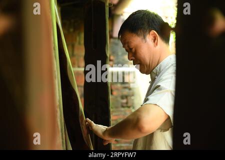 200630 -- HANGZHOU, le 30 juin 2020 -- Ma Yuesi vérifie Guqin, un instrument de musique chinois traditionnel, chez lui dans le village de Yalan, dans le district de Yuhang, à Hangzhou, dans la province du Zhejiang, dans l'est de la Chine, le 30 juin 2020. Ma Yuesi, 58 ans, a choisi d'être un fabricant de Guqin quand il avait 24 ans. Au fil des ans, en tant qu’héritier du patrimoine culturel immatériel, Ma ne cesse d’améliorer ses compétences. Je n'ai jamais fait un Guqin parfait, dit-il, si un jour je le fais, je veux écrire un livre pour transmettre l'artisanat aux générations futures. CHINE-ZHEJIANG-HANGZHOU-GUQIN MAKER CN WENGXXINYANG PUBLICATIONXNOTXINXCHN Banque D'Images