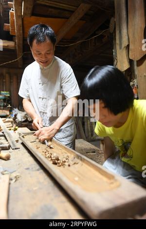 200630 -- HANGZHOU, le 30 juin 2020 -- Ma Yuesi L fabrique Guqin, un instrument de musique traditionnel chinois, chez lui dans le village de Yalan, dans le district de Yuhang, à Hangzhou, dans la province du Zhejiang de l'est de la Chine, le 30 juin 2020. Ma Yuesi, 58 ans, a choisi d'être un fabricant de Guqin quand il avait 24 ans. Au fil des ans, en tant qu’héritier du patrimoine culturel immatériel, Ma ne cesse d’améliorer ses compétences. Je n'ai jamais fait un Guqin parfait, dit-il, si un jour je le fais, je veux écrire un livre pour transmettre l'artisanat aux générations futures. CHINE-ZHEJIANG-HANGZHOU-GUQIN MAKER CN WENGXXINYANG PUBLICATIONXNOTXINXCHN Banque D'Images