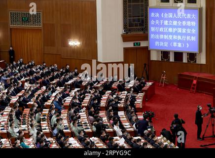 200701 -- BEIJING, 1 juillet 2020 -- les députés du 13e Congrès populaire national votent à une écrasante majorité pour approuver la décision du NPC sur l'établissement et l'amélioration du système juridique et des mécanismes d'application pour la région administrative spéciale de Hong Kong afin de sauvegarder la sécurité nationale lors de la séance de clôture de la troisième session du 13e peuple national s Congrès à Pékin, capitale de la Chine, 28 mai 2020. POUR ALLER AVEC LES TITRES XINHUA DU 1 JUILLET 2020 CHINE-HONG KONG-ANNIVERSAIRE-CÉLÉBRATION CN DINGXHAITAO PUBLICATIONXNOTXINXCHN Banque D'Images