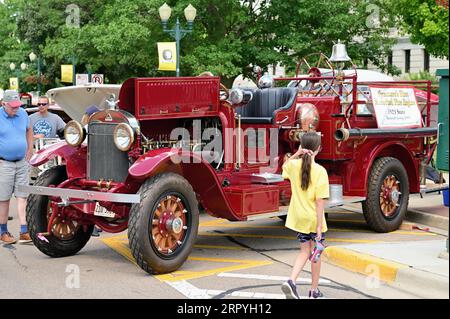 Sycamore, Illinois, États-Unis. Un salon annuel de voitures anciennes dominant les rues principales d'une petite communauté dans le nord-est de l'Illinois. Une jeune fille qui se fait lire Banque D'Images