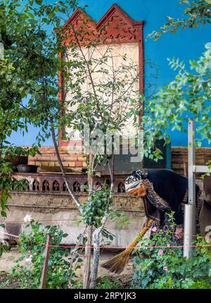 200705 -- YINING, le 5 juillet 2020 -- une vieille femme effectue des travaux de nettoyage devant une maison de la rue Liuxing dans la ville de Yining, dans la région autonome ouïgoure du Xinjiang, au nord-ouest de la Chine, le 5 juillet 2020. La rue Liuxing, construite dans les années 1930, est un bloc historique bien connu de la ville de Yining. Dans le cadre des efforts des autorités locales pour préserver et améliorer le bloc historique au cours des dernières années, la rue a vu son style historique préservé et le cadre de vie des résidents locaux amélioré en même temps, attirant ainsi beaucoup de touristes pour le tourisme et les entrepreneurs pour l'investissement. CHINE-XINJIANG-YI Banque D'Images