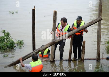 200714 -- ZONGYANG, le 14 juillet 2020 -- des villageois bloquent une canalisation sur le remblai d'une île fluviale dans le canton de Changsha, dans le comté de Zongyang, dans l'est de la province d'Anhui, le 14 juillet 2020. Les responsables locaux et les résidents de la municipalité de Changsha luttent contre la tuyauterie de remblai de l'île-rivière déclenchée par la montée croissante des eaux du fleuve Yangtze. Tous les résidents de l'île ont été relogés en lieu sûr. CHINA-ANHUI-ZONGYANG-FLOOD CONTROL CN HUANGXBOHAN PUBLICATIONXNOTXINXCHN Banque D'Images