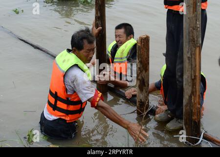 200714 -- ZONGYANG, le 14 juillet 2020 -- des villageois tentent de bloquer la tuyauterie sur le remblai d'une île fluviale dans le canton de Changsha, dans le comté de Zongyang, dans l'est de la province d'Anhui, le 14 juillet 2020. Les responsables locaux et les résidents de la municipalité de Changsha luttent contre la tuyauterie de remblai de l'île-rivière déclenchée par la montée croissante des eaux du fleuve Yangtze. Tous les résidents de l'île ont été relogés en lieu sûr. CHINA-ANHUI-ZONGYANG-FLOOD CONTROL CN HUANGXBOHAN PUBLICATIONXNOTXINXCHN Banque D'Images