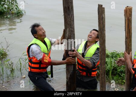 200714 -- ZONGYANG, le 14 juillet 2020 -- des villageois tentent de bloquer la tuyauterie sur le remblai d'une île fluviale dans le canton de Changsha, dans le comté de Zongyang, dans l'est de la province d'Anhui, le 14 juillet 2020. Les responsables locaux et les résidents de la municipalité de Changsha luttent contre la tuyauterie de remblai de l'île-rivière déclenchée par la montée croissante des eaux du fleuve Yangtze. Tous les résidents de l'île ont été relogés en lieu sûr. CHINA-ANHUI-ZONGYANG-FLOOD CONTROL CN HUANGXBOHAN PUBLICATIONXNOTXINXCHN Banque D'Images