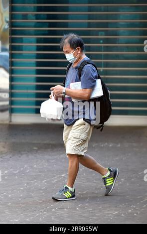 200729 -- HONG KONG, le 29 juillet 2020 Xinhua -- Un homme porte sa nourriture à emporter à Hong Kong, dans le sud de la Chine, le 29 juillet 2020. Des mesures de distanciation sociale plus strictes ont pris effet mercredi à Hong Kong. Les services de restauration dans les restaurants sont interdits. Xinhua/Lo Ping FAI CHINE-HONG KONG-COVID-19-MESURES DE DISTANCIATION SOCIALE CN PUBLICATIONxNOTxINxCHN Banque D'Images