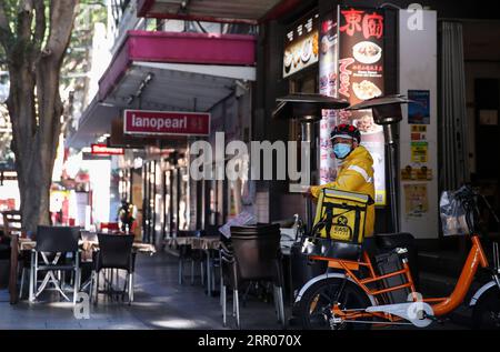 200731 -- SYDNEY, le 31 juillet 2020 -- Un livreur attend devant un restaurant dans Chinatown de Sydney, Australie, le 29 juillet 2020. Maintenant, avec des cas records de COVID-19 dans la ville de Melbourne et Sydney qui sont potentiellement au bord d’une deuxième vague, les restaurants et les bars se préparent à être frappés par un retour au confinement alors qu’ils luttent pour survivre. POUR ALLER AVEC la caractéristique : les restaurants emblématiques de Chinatown de Sydney s adaptent à la vie sous COVID-19 AUSTRALIA-SYDNEY-COVID-19-CHINATOWN-EATERIES BaixXuefei PUBLICATIONxNOTxINxCHN Banque D'Images