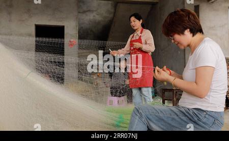 200801 -- LIANYUNGANG, 1 août 2020 -- des femmes réparent des filets de pêche dans la ville de Haitou à Lianyungang, dans la province du Jiangsu de l est de la Chine, le 1 juillet 2020. Après le boom des plateformes de diffusion en direct et du commerce électronique en Chine, le commerce électronique en streaming en direct a connu un développement rapide et créé de nouvelles opportunités d'emploi. Dans la ville de Haitou, plus de 3 000 personnes sont passées à la vente en direct. Ces streamers en direct travaillent souvent de nuit à l'aube pour vendre des produits marins locaux et d'autres spécialités. Dans la journée, les marchandises vendues en streaming en direct seront envoyées à leurs consommateurs par livraison express par emplo local Banque D'Images