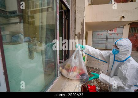 200805 -- URUMQI, 5 août 2020 -- un volontaire Ekebar Emet reçoit des légumes commandés par Internet par les résidents de la communauté dans un magasin de légumes du district de Tianshan à Urumqi, dans la région autonome Uygur du Xinjiang, au nord-ouest de la Chine, 3 août 2020. Ekebar Emet, un étudiant de 21 ans, vient du comté de Bachu, dans le Xinjiang. Il est allé à la communauté Dongcaiyuan dans le district de Tianshan de la ville d'Urumqi pour pratiquer pendant un an le 3 juin. La résurgence soudaine de la COVID-19 au Xinjiang a immédiatement transformé Ekebar de stagiaire universitaire en bénévole en première ligne de la prévention et du contrôle des épidémies. Banque D'Images