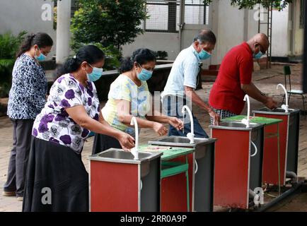 200805 -- COLOMBO, le 5 août 2020 -- des électeurs se nettoient les mains dans un bureau de vote à Colombo, au Sri Lanka, le 5 août 2020. Une participation électorale estimée à 40 pour cent a été enregistrée lors des élections législatives du Sri Lanka mercredi midi, après le début du scrutin à 7 heures, heure locale, a indiqué le département d'information du gouvernement. Photo de /Xinhua SRI LANKA-PARLIMENTARY ELECTION-VOTING AjithxPerera PUBLICATIONxNOTxINxCHN Banque D'Images