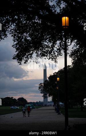 200808 -- WASHINGTON, D.C., 8 août 2020 -- les gens marchent sur le National Mall au coucher du soleil près du Washington Monument à Washington, D.C., États-Unis, 7 août 2020. Le taux de chômage américain a chuté en juillet pour le troisième mois consécutif, indiquant une amélioration du marché du travail ravagé par la pandémie de COVID-19. Mais les analystes avertissent que des incertitudes subsistent et que la reprise a encore beaucoup de chemin à parcourir. Les employeurs américains ont ajouté 1,8 millions d'emplois en juillet, et le taux de chômage est tombé à 10,2 pour cent au milieu des efforts de réouverture, a rapporté vendredi le Bureau of Labor Statistics des États-Unis. ÉTATS-UNIS-WASHINGTON, D.C.-UNEMPL Banque D'Images