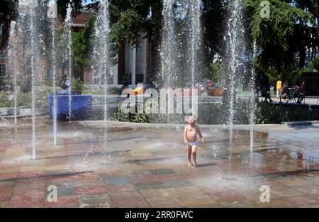 200813 -- TIRANA, 13 août 2020 -- Un enfant se refroidit dans des fontaines sur la place Skanderbeg, au centre de la capitale Tirana, Albanie, le 12 août 2020. L'Albanie a été frappée par une vague de chaleur avec une température atteignant 39 degrés Celsius mercredi. ALBANIE-TIRANA-TEMPS CHAUD ArbenxCeli PUBLICATIONxNOTxINxCHN Banque D'Images