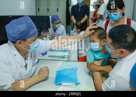 200817 -- BEIJING, 17 août 2020 -- Liu Qingquan 1st L examine un enfant à l'hôpital de médecine traditionnelle chinoise de Beijing, capitale de la Chine, le 11 août 2020. Liu est le président de l'hôpital de Pékin de médecine traditionnelle chinoise MTC. Il s’est rendu à Wuhan en janvier en tant que membre de l’équipe d’experts de haut niveau de la Commission nationale de la santé pour étudier la réponse locale au COVID-19 et est devenu le chef de l’hôpital temporaire de Jiangxia, un hôpital temporaire axé sur la MTC à Wuhan. Le travail de Liu et d'autres experts de l'équipe à Wuhan a ouvert la voie à une implication profonde de TCM dans la lutte contre les agissements Banque D'Images