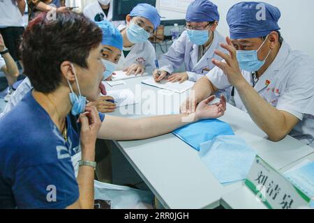 200817 -- BEIJING, 17 août 2020 -- Liu Qingquan 1st R examine un patient à l'hôpital de médecine traditionnelle chinoise de Beijing, capitale de la Chine, le 11 août 2020. Liu est le président de l'hôpital de Pékin de médecine traditionnelle chinoise MTC. Il s’est rendu à Wuhan en janvier en tant que membre de l’équipe d’experts de haut niveau de la Commission nationale de la santé pour étudier la réponse locale au COVID-19 et est devenu le chef de l’hôpital temporaire de Jiangxia, un hôpital temporaire axé sur la MTC à Wuhan. Le travail de Liu et d'autres experts de l'équipe à Wuhan a ouvert la voie à une implication profonde de TCM dans le combat agai Banque D'Images