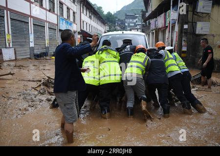 200817 -- LONGNAN, 17 août 2020 -- la police locale de la circulation vient en aide à un véhicule échoué dans le district de Wudu de Longnan City, dans la province du Gansu du nord-ouest de la Chine, le 17 août 2020. Des pluies torrentielles d'une semaine dans la province du Gansu ont conduit à un affluent du fleuve Yangtsé au-dessus du niveau de danger alors que les autorités locales combattent diverses catastrophes provoquées par la pluie, y compris des torrents de montagne, des glissements de terrain et des coulées de boue. Lundi, les pluies ont endommagé 3 303 km de routes dans la ville de Longnan, perturbant la circulation sur 497 routes. Plus de 38 000 personnes ont été relocalisées à Longnan. SPOT NEWSCHINA-GANSU-LONGNAN-HEAVY RAINBOW-DISAS Banque D'Images