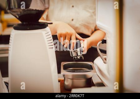 Préparation du barista falsification du café dans le porte-filtre pour préparer du café frais. Banque D'Images