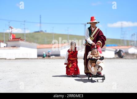 200820 -- GOLOG, le 20 août 2020 -- Villager Lhamo se promène avec son fils et sa fille dans le village de Ghadan, dans le canton de Machali, comté de Madoi, préfecture autonome tibétaine de Golog, province du Qinghai au nord-ouest de la Chine, le 19 août 2020. En octobre 2018, un total de 1 036 résidents pauvres enregistrés ont déménagé des terres moins accueillantes du comté de Madoi à Ghadan, un village de relocalisation nouvellement construit dans la zone source du fleuve jaune. Le nouveau village dispose de meilleurs moyens de transport, ce qui permet aux villageois de trouver plus facilement du travail ou de démarrer des entreprises dans d'autres villes. Pendant ce temps, de nombreux villageois sont payés Banque D'Images