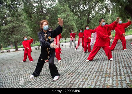 200820 -- BEIJING, 20 août 2020 -- Yang Shuqin 2nd L enseigne aux personnes âgées les mouvements aérobiques traditionnels chinois au parc du Temple of Heaven à Beijing, capitale de la Chine, le 19 août 2020. Pour Zhang Liangui, 68 ans, le Temple du ciel signifie plus qu'un site du patrimoine mondial de l'UNESCO, puisqu'il fait souvent de l'exercice matinal dans le parc autour du site historique. Le 17 août, Zhang est venu tôt pour se réchauffer dans une clairière entourée de murs rouges et d'arbres verts au milieu des échos d'oiseaux et d'insectes. Coups de pied, accroupissement, jeu d'épée Taiji, un ensemble de mouvements d'échauffement ont montré son physique souple et robuste. WHI Banque D'Images