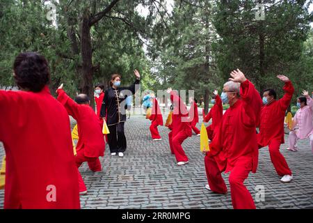 200820 -- BEIJING, 20 août 2020 -- Yang Shuqin 4th L enseigne aux personnes âgées les mouvements aérobiques traditionnels chinois au parc du Temple of Heaven à Beijing, capitale de la Chine, le 19 août 2020. Pour Zhang Liangui, 68 ans, le Temple du ciel signifie plus qu'un site du patrimoine mondial de l'UNESCO, puisqu'il fait souvent de l'exercice matinal dans le parc autour du site historique. Le 17 août, Zhang est venu tôt pour se réchauffer dans une clairière entourée de murs rouges et d'arbres verts au milieu des échos d'oiseaux et d'insectes. Coups de pied, accroupissement, jeu d'épée Taiji, un ensemble de mouvements d'échauffement ont montré son physique souple et robuste. WHI Banque D'Images