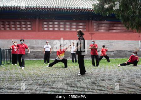 200820 -- BEIJING, 20 août 2020 -- des personnes âgées pratiquent les mouvements aérobiques chinois traditionnels au parc du Temple du ciel à Beijing, capitale de la Chine, le 17 août 2020. Pour Zhang Liangui, 68 ans, le Temple du ciel signifie plus qu'un site du patrimoine mondial de l'UNESCO, puisqu'il fait souvent de l'exercice matinal dans le parc autour du site historique. Le 17 août, Zhang est venu tôt pour se réchauffer dans une clairière entourée de murs rouges et d'arbres verts au milieu des échos d'oiseaux et d'insectes. Coups de pied, accroupissement, jeu d'épée Taiji, un ensemble de mouvements d'échauffement ont montré son physique souple et robuste. En s'échauffant, lui Banque D'Images