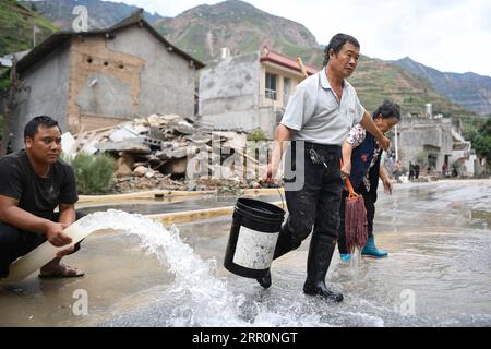 200821 -- LONGNAN, 21 août 2020 -- des gens dégagent le limon sur une route dans le village de Toufangjie de la ville de Waina dans le district de Wudu, Longnan dans la province du Gansu du nord-ouest de la Chine, 21 août 2020. Récemment, les catastrophes naturelles déclenchées par de fortes pluies ont durement touché la ville de Longnan. Les travaux de reconstruction post-catastrophe ont commencé juste après le recul des inondations pour aider à retrouver une vie normale dans les zones touchées par les inondations. CHINE-GANSU-LONGNAN-FORTES PRÉCIPITATIONS-CONSÉQUENCES CN CHENXBIN PUBLICATIONXNOTXINXCHN Banque D'Images