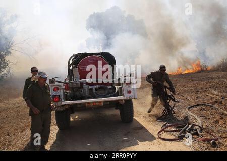 200823 -- NIR AM, 23 août 2020 -- des soldats israéliens tentent d'éteindre le feu dans une zone proche de la frontière entre Israël et la bande de Gaza, près du kibboutz du sud israélien de NIR Am, le 23 août 2020. Depuis août 6, Gaza a été témoin de tensions militaires avec l’armée israélienne, alors que les jeunes Palestiniens ont rétabli le lancement de ballons incendiaires vers les villes israéliennes adjacentes à la bande. En conséquence, des avions de combat israéliens ont ciblé des dizaines de sites militaires appartenant au mouvement Hamas, en réponse au lancement de ballons incendiaires. Photo de /Xinhua ISRAEL-NIR AM-FIRE PUBLICATION GilxCohenxMagen Banque D'Images