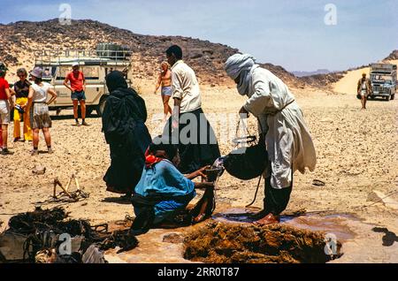 Nomades puisant de l'eau dans un puits, groupe touristique Minitrek expéditions, près de Djanet, Algérie, Afrique du Nord 1973 Banque D'Images