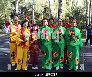 200828 -- BEIJING, 28 août 2020 -- Dong Shulin 1e L, arrière, Mei Yongpei 1e L, avant et Dong Yutong 2e L, avant posent avec leurs amis sur la place de la culture Wukesong Diabolo à Beijing, capitale de la Chine, le 11 août 2020. Dong Shulin, 66 ans, vit avec sa femme Mei Yongpei et sa petite-fille de 9 ans, Dong Yutong, à Pékin. Dong Shulin a commencé à jouer au diabolo en 2003 et maintenant toute la famille aime jouer à ce jeu folklorique traditionnel, dans lequel on peut lancer et attraper une toupie en déplaçant un cordon attaché à deux bâtons. Dans la maison de Dong Shulin, plus de 70 diabolos ont été placés tout autour. Certains Banque D'Images