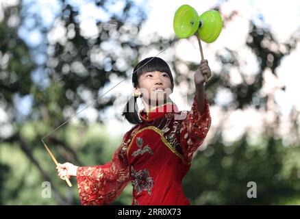 200828 -- BEIJING, 28 août 2020 -- Dong Yutong joue au diabolo sur la place culturelle Wukesong Diabolo à Beijing, capitale de la Chine, le 11 août 2020. Dong Shulin, 66 ans, vit avec sa femme Mei Yongpei et sa petite-fille de 9 ans, Dong Yutong, à Pékin. Dong Shulin a commencé à jouer au diabolo en 2003 et maintenant toute la famille aime jouer à ce jeu folklorique traditionnel, dans lequel on peut lancer et attraper une toupie en déplaçant un cordon attaché à deux bâtons. Dans la maison de Dong Shulin, plus de 70 diabolos ont été placés tout autour. Certains des diabolos ont été achetés et d'autres ont été faits maison, en particulier le grand Banque D'Images