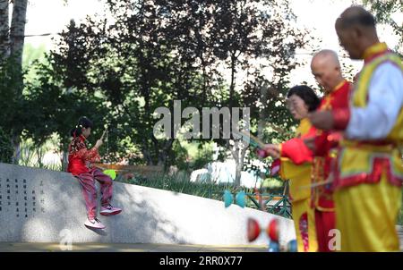 200828 -- BEIJING, 28 août 2020 -- Dong Yutong 1st L joue au diabolo sur la place de la culture Wukesong Diabolo à Beijing, capitale de la Chine, le 11 août 2020. Dong Shulin, 66 ans, vit avec sa femme Mei Yongpei et sa petite-fille de 9 ans, Dong Yutong, à Pékin. Dong Shulin a commencé à jouer au diabolo en 2003 et maintenant toute la famille aime jouer à ce jeu folklorique traditionnel, dans lequel on peut lancer et attraper une toupie en déplaçant un cordon attaché à deux bâtons. Dans la maison de Dong Shulin, plus de 70 diabolos ont été placés tout autour. Certains des diabolos ont été achetés et d'autres ont été faits maison, en particulier TH Banque D'Images