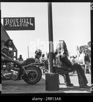 Motos Harley Davidson garées et motards traînant devant la Boot Hill Saloon pendant la Daytona Bike week en mars 1986 à Daytona Beach, Floride, États-Unis Banque D'Images