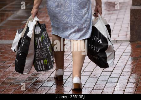 200902 -- READING BRITAIN, 2 septembre 2020 -- Une femme porte des sacs en plastique dans une rue à Reading, en Grande-Bretagne, le 2 septembre 2020. Dans le cadre de sa stratégie de protection des océans contre les déchets plastiques, le gouvernement britannique a décidé que tous les magasins du pays devront facturer 10 pence environ 13 cents américains pour les sacs de transport à usage unique à partir d’avril prochain. Photo de /Xinhua BRITAIN-READING-PLASTIC BAGS-CHARGE-AVRIL 2021 TimxIreland PUBLICATIONxNOTxINxCHN Banque D'Images