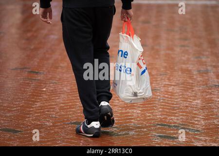 200902 -- READING BRITAIN, 2 septembre 2020 -- Une personne porte un sac en plastique dans une rue à Reading, en Grande-Bretagne, le 2 septembre 2020. Dans le cadre de sa stratégie de protection des océans contre les déchets plastiques, le gouvernement britannique a décidé que tous les magasins du pays devront facturer 10 pence environ 13 cents américains pour les sacs de transport à usage unique à partir d’avril prochain. Photo de /Xinhua BRITAIN-READING-PLASTIC BAGS-CHARGE-AVRIL 2021 TimxIreland PUBLICATIONxNOTxINxCHN Banque D'Images